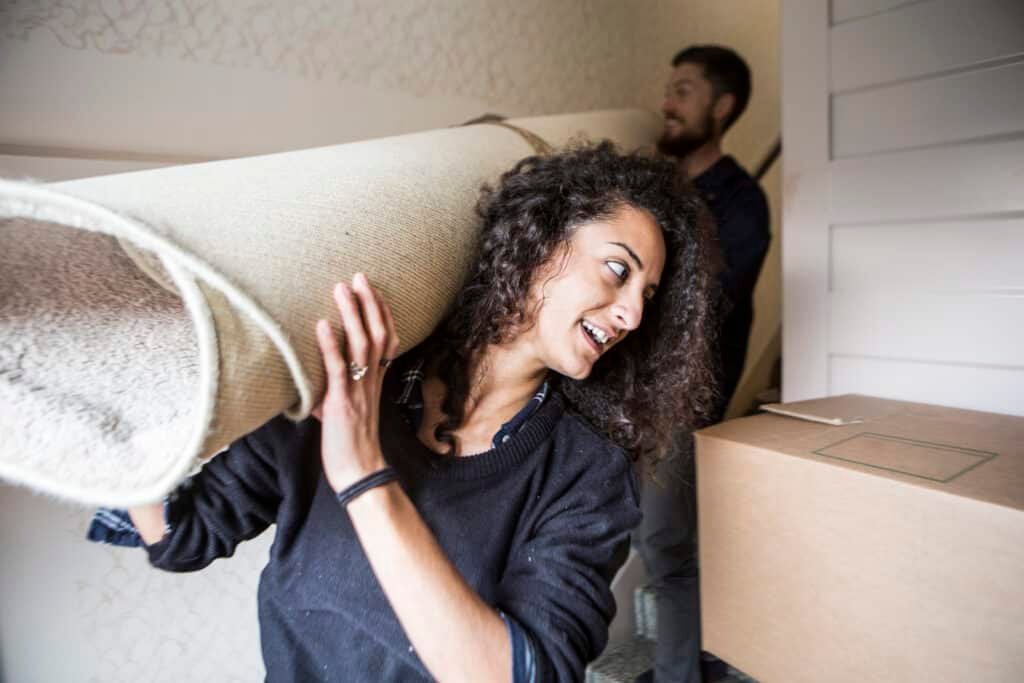woman and man carrying carpet while moving house 2024 10 11 11 32 02 utc