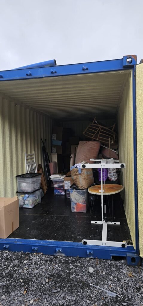 Inside a shipping container packed with household items, including furniture and boxes, ready for moving from Dublin to Sligo.