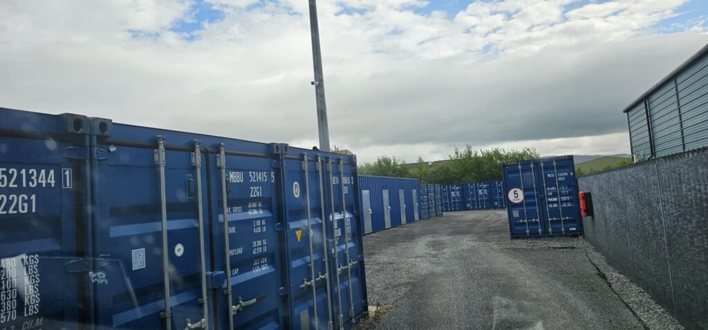 Row of blue shipping containers at a storage facility, suggesting options for moving from Dublin to Sligo.