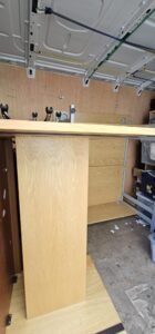 Inside a moving van, a wooden desk and shelving unit are being transported, showcasing professional commercial relocation by local movers.
